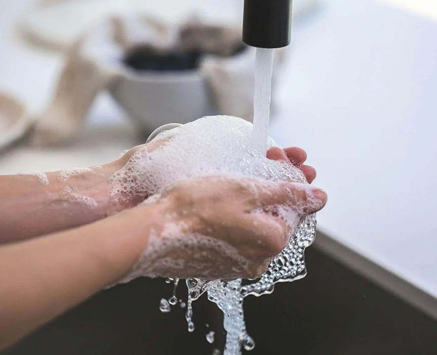 Personne se lavant les mains avec du savon sous l'eau