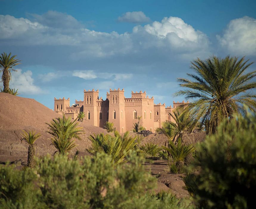 Kasbah traditionnelle marocaine entourée de palmiers dans le désert