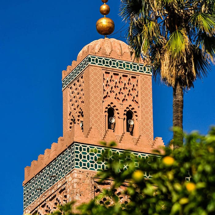  Minaret marocain traditionnel avec motifs, palmier et ciel bleu