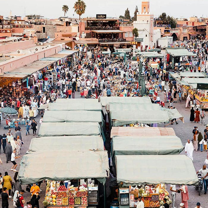 Marché animé avec stands couverts et foule nombreuse