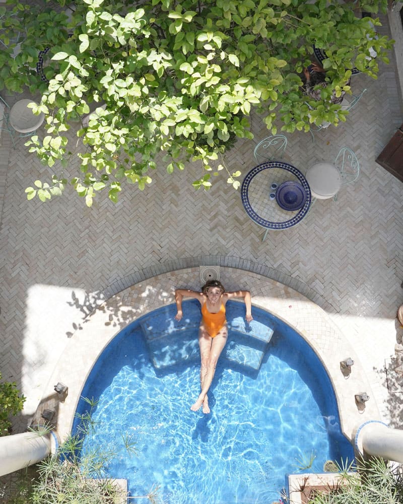 Femme se relaxant dans une petite piscine entourée de verdure