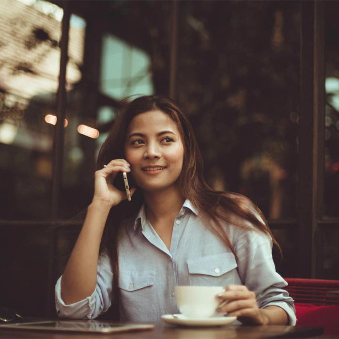 Femme au téléphone à la terrasse d'un café