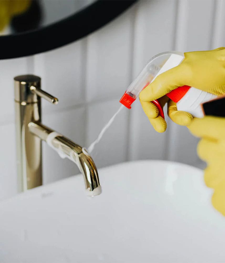 Nettoyage d'un robinet de lavabo avec spray