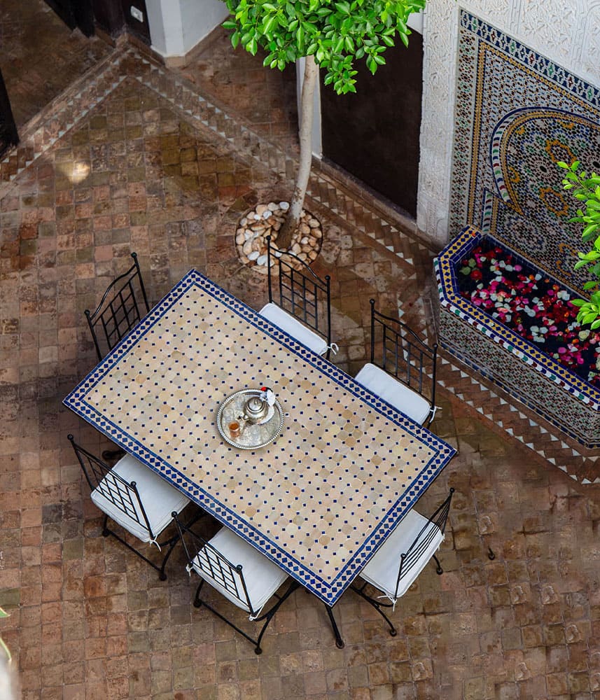 Table de mosaïque et fontaine dans une cour intérieure