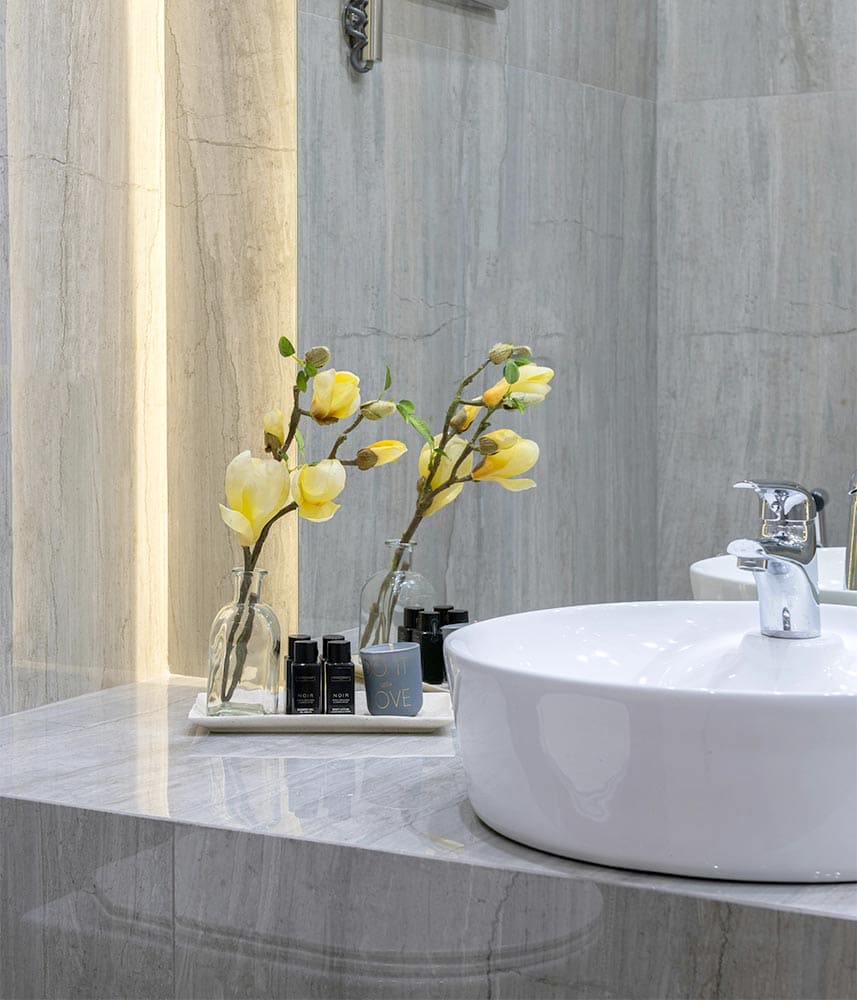 Salle de bain avec lavabo rond, fleurs jaunes et accessoires