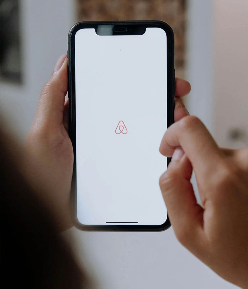 Personne utilisant l'application Airbnb sur un smartphone