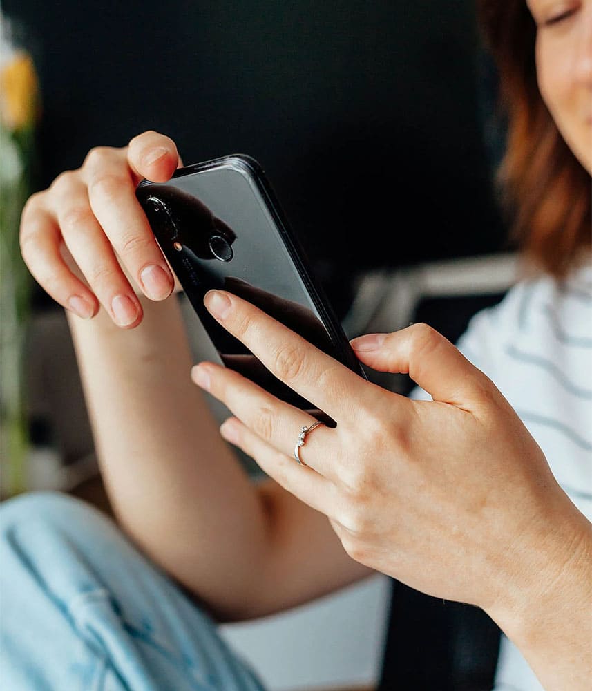 Femme utilisant un smartphone, illustrant la gestion des réservations