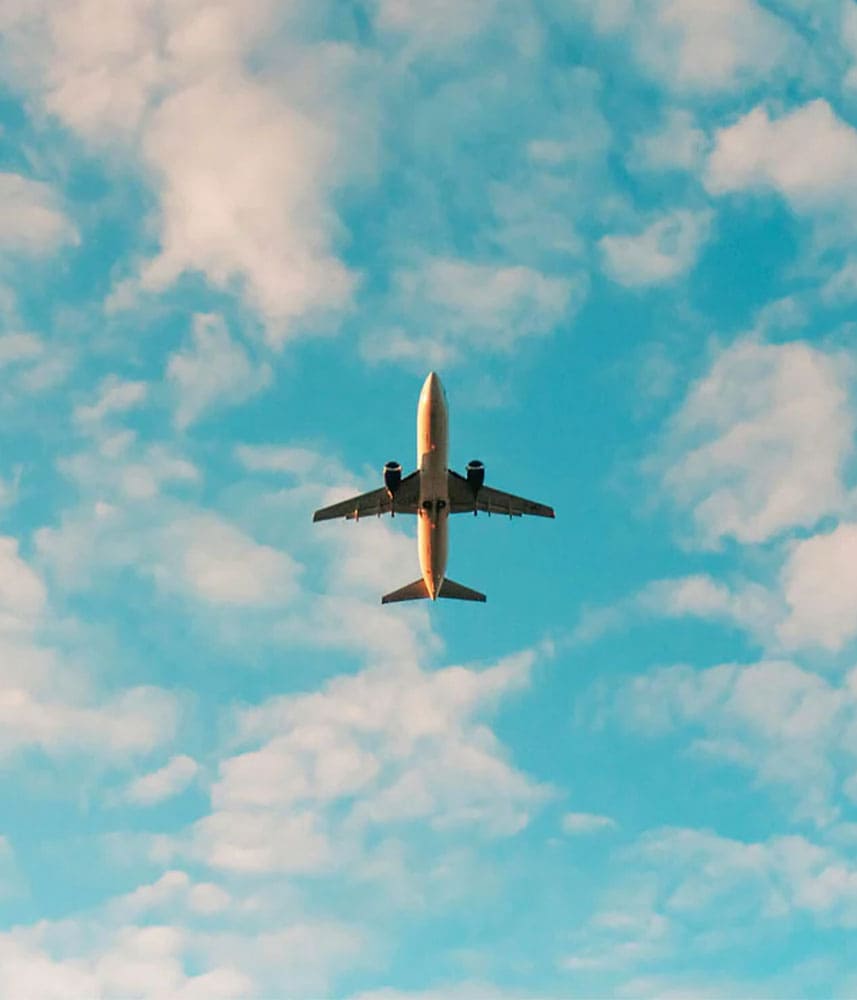 Avion en vol sous un ciel bleu avec des nuages