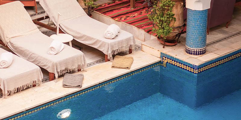 Chaises longues et coin salon confortable près de la piscine intérieure