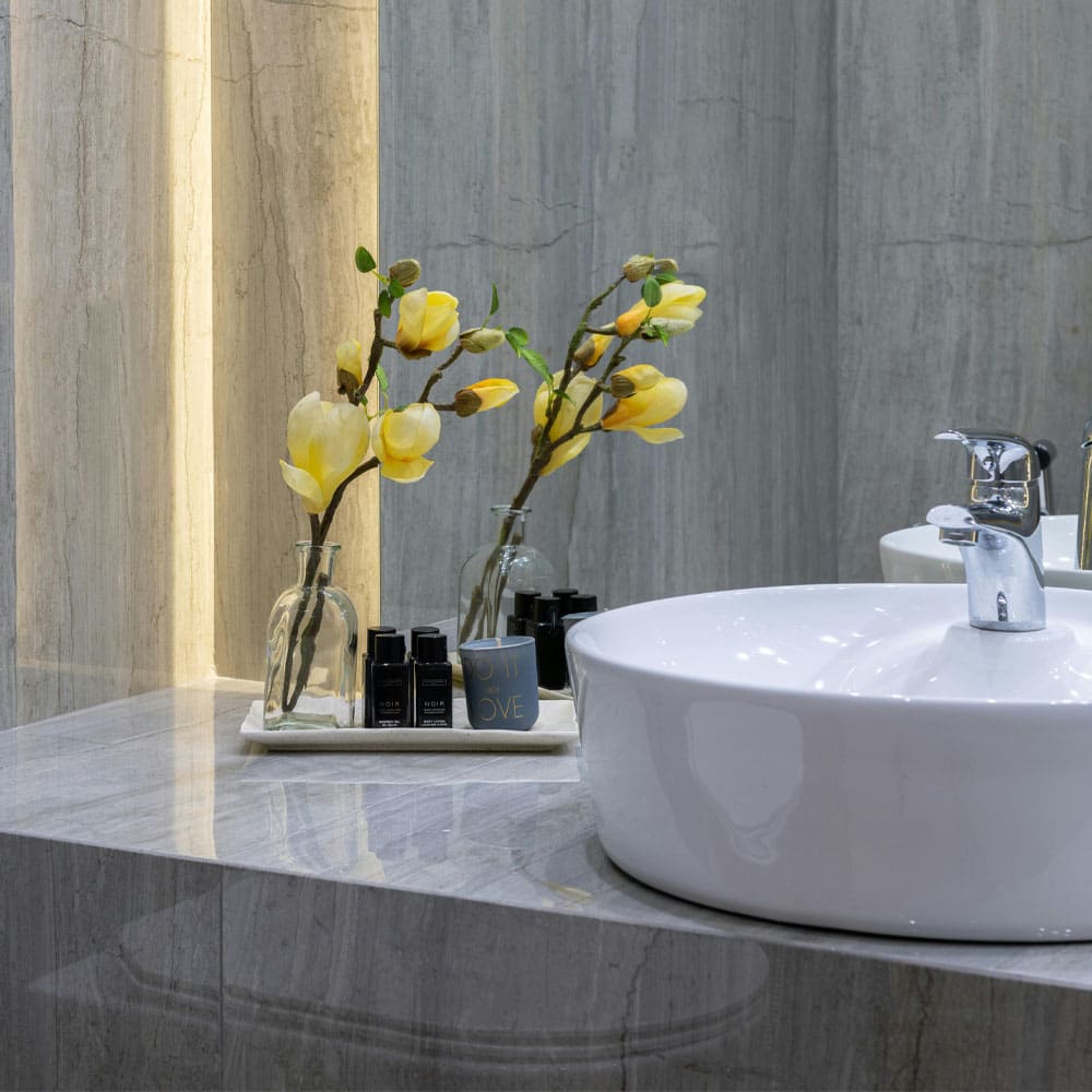 Salle de bain moderne avec lavabo rond, fleurs jaunes et accessoires