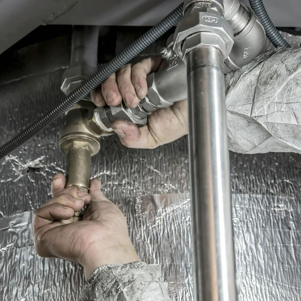 Plombier travaillant sur des tuyaux en métal