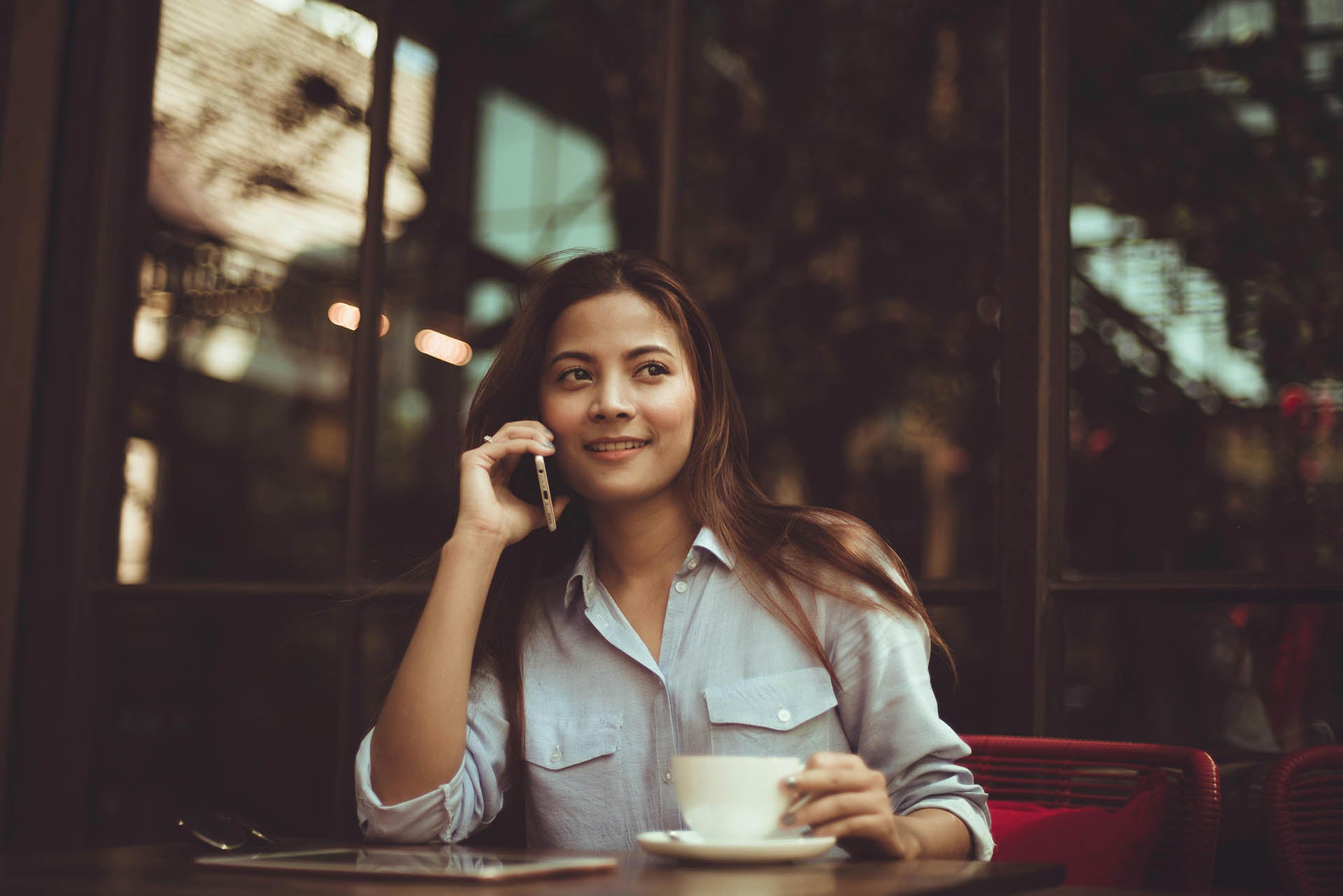 Femme au téléphone à la terrasse d'un café