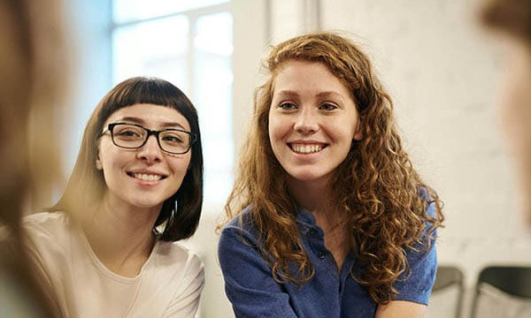 Deux femmes souriantes discutant ensemble