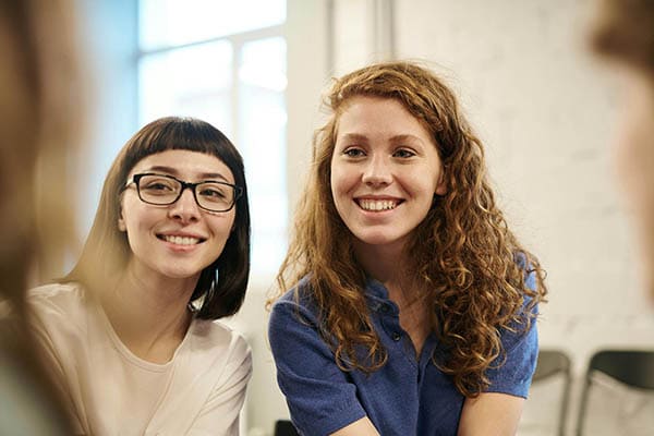 Deux femmes souriantes discutant ensemble